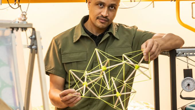 DK Osseo-Asare holding an architectural model in his Humanitarian Materials Lab.