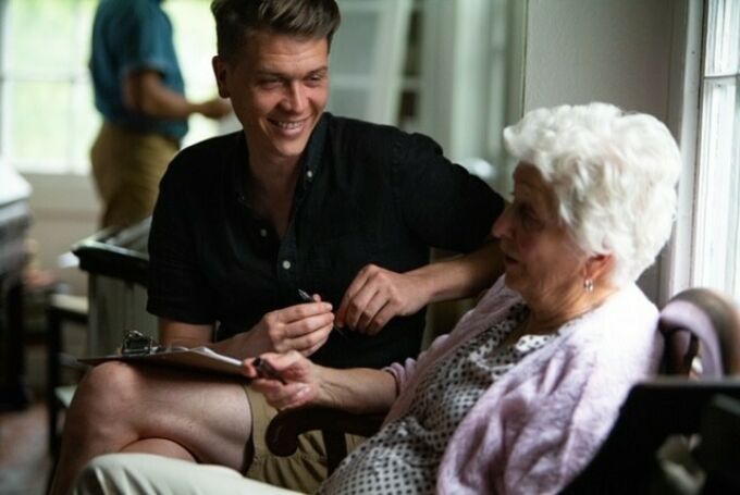 Young man talking to elderly woman