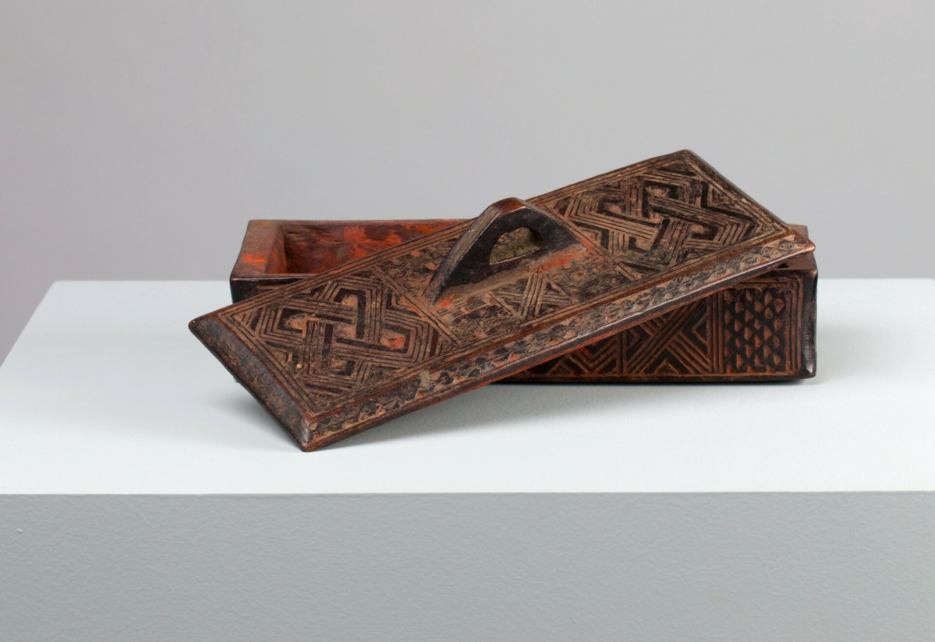 A 20th century decorated wooden box called a Tukula container produced by Kuba carvers from the Democratic Rebublic of the Congo.