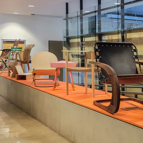 Chairs crafted by Stuckeman School students, faculty, and alumni align a section of the first floor of the Stuckeman Family Building.