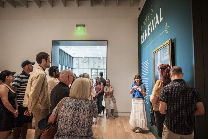 A guided tour at a museum in front of a teal wall