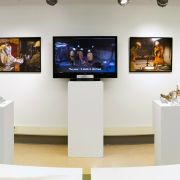 A series of screens on pedestals in the Borland Project Space showcasing videos of art and research projects