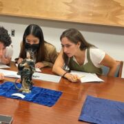 Art history students examine a sculpture.