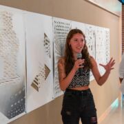 Student holding microphone, presenting architectural work at the annual Corbelletti Competition.