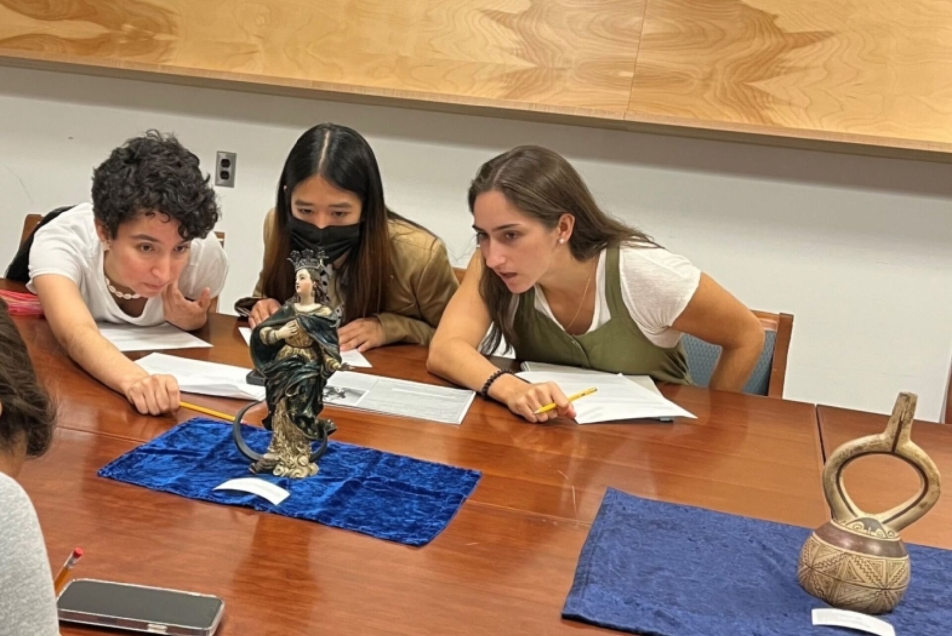Art history students examine a sculpture.