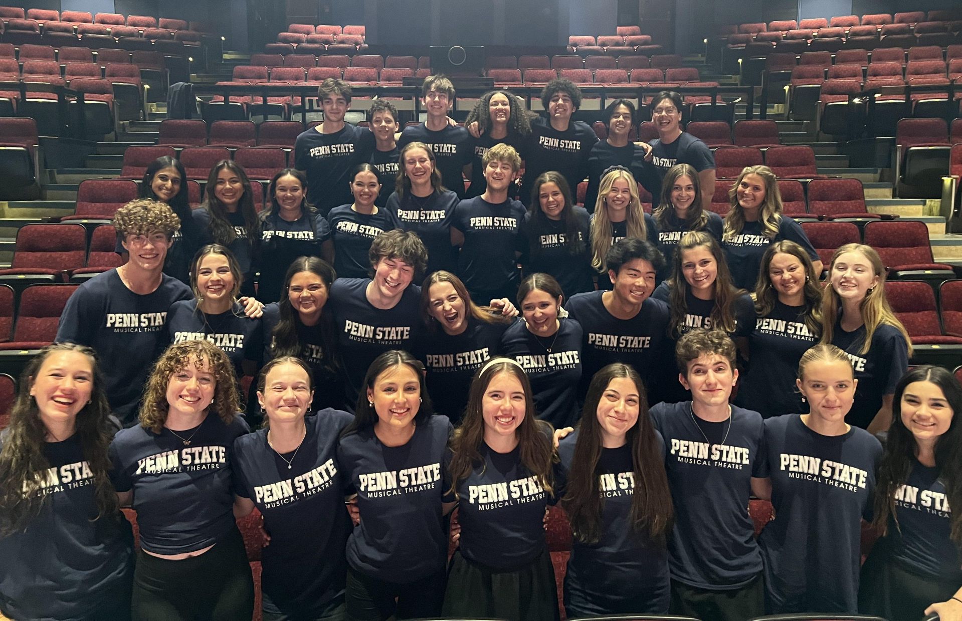 group of students having a good time sitting in the school of theatre getting their photo taken during training.