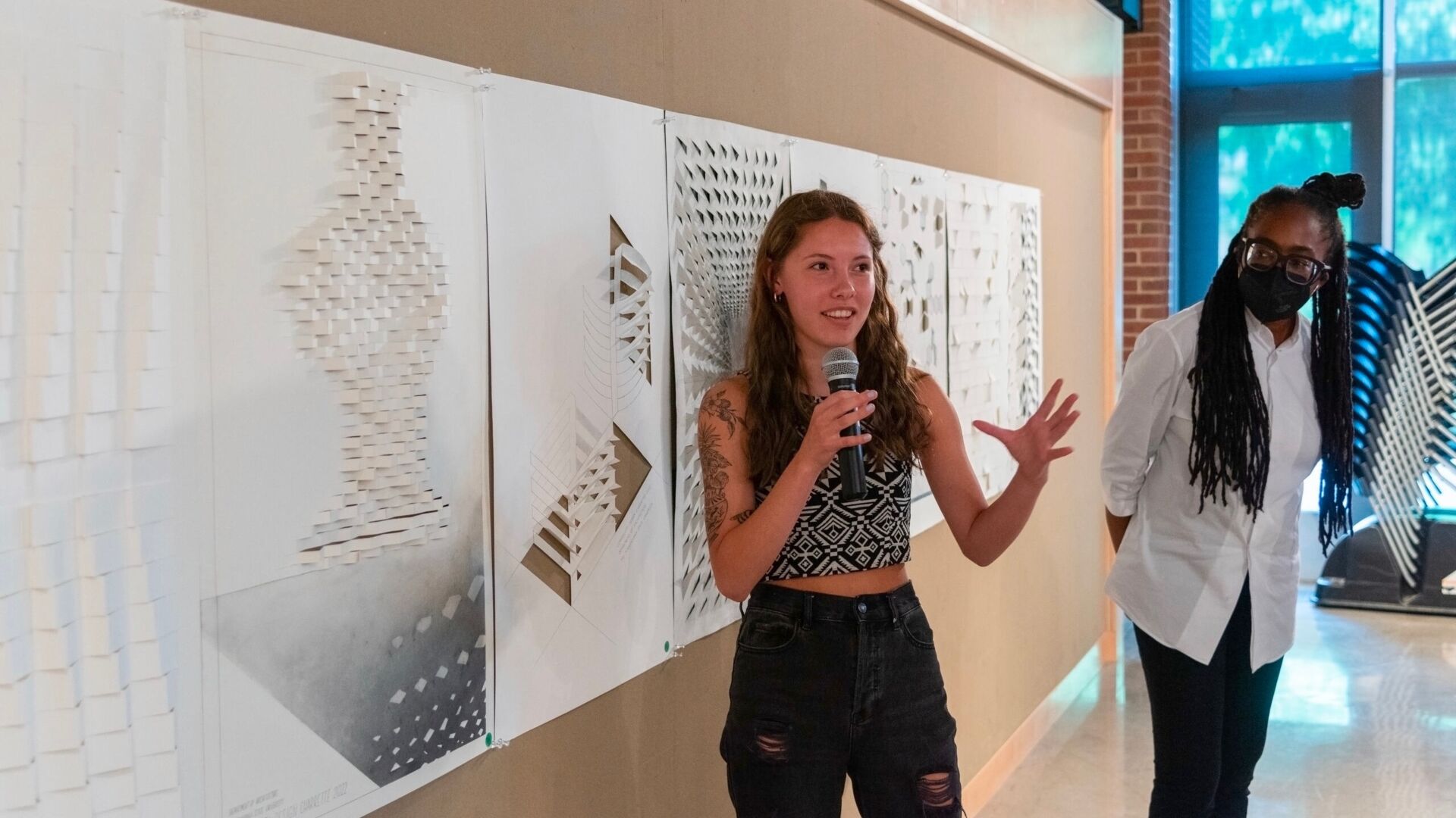 Student holding microphone, presenting architectural work at the annual Corbelletti Competition.