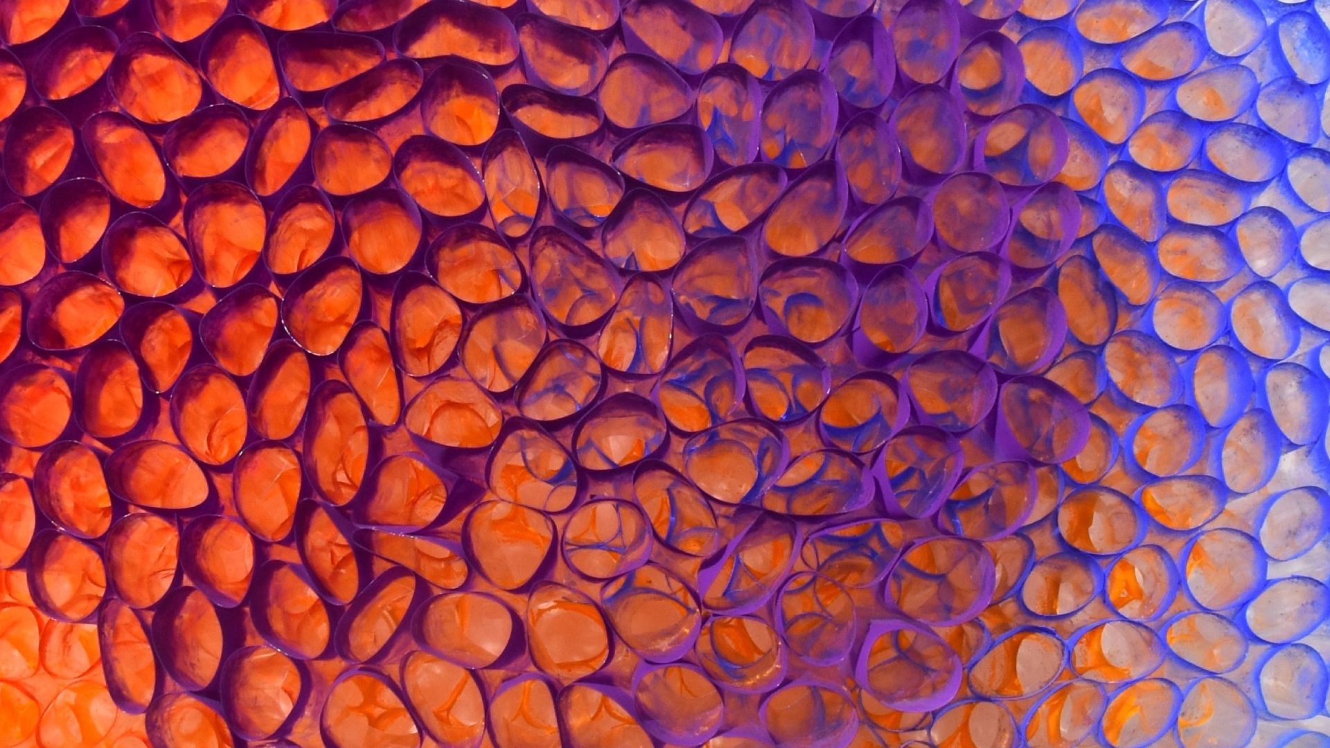 Artwork featuring packed, swirling raised cellular forms overlaying an orange to white painted background.