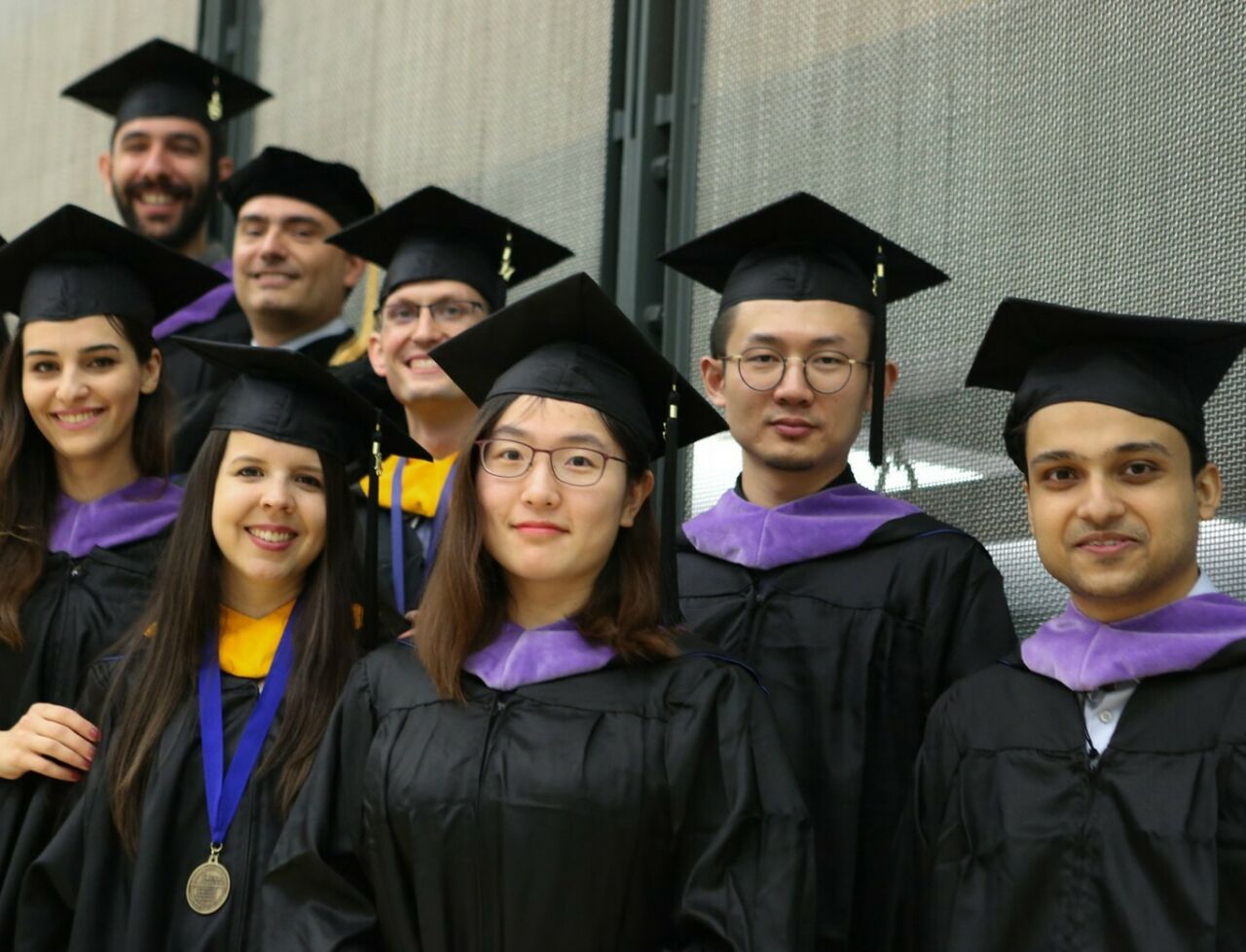 Diverse group of graduating students wearing regalia.