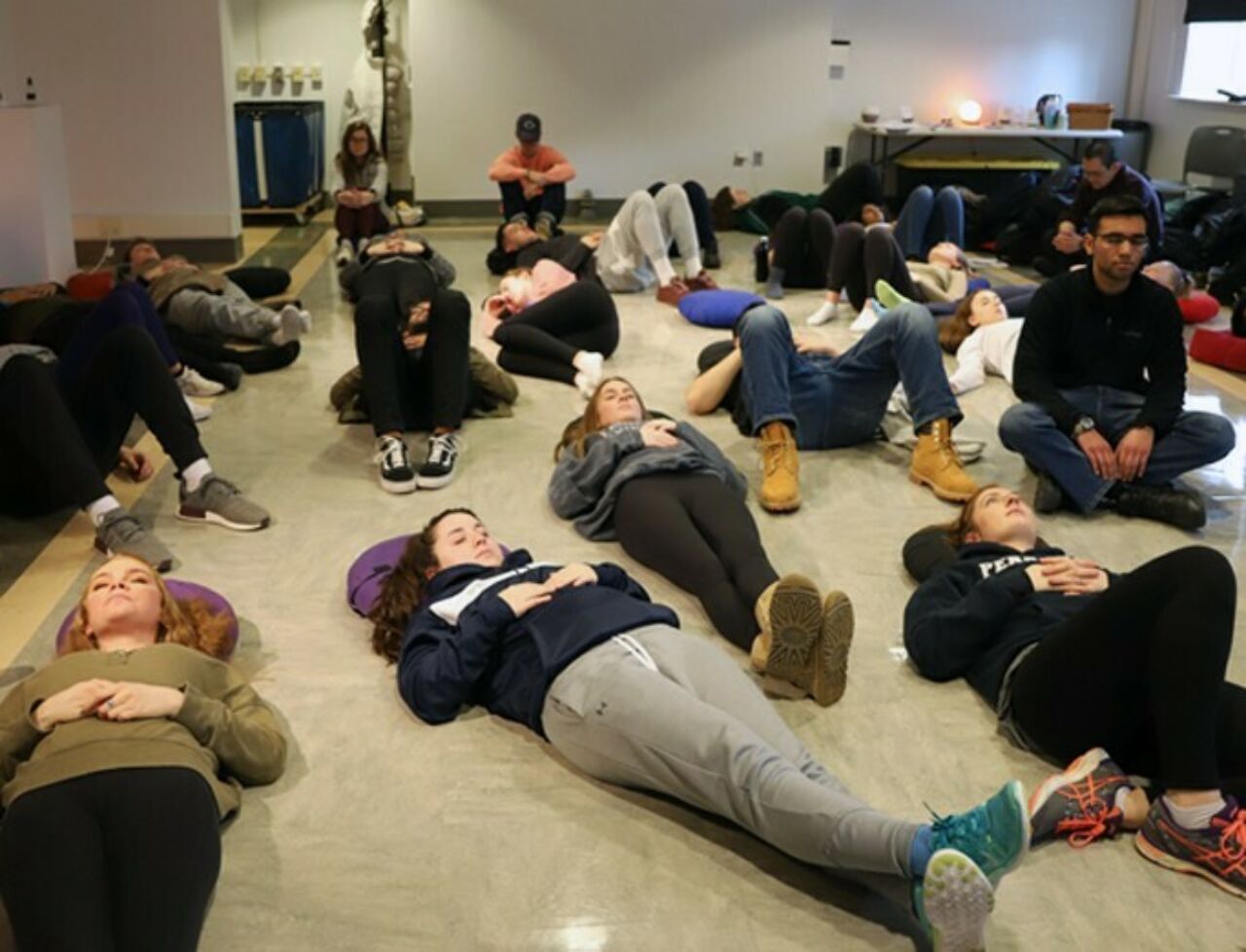 An array of students lying peacefully on the floor participating in a Zen Den Mindfulness exercise.