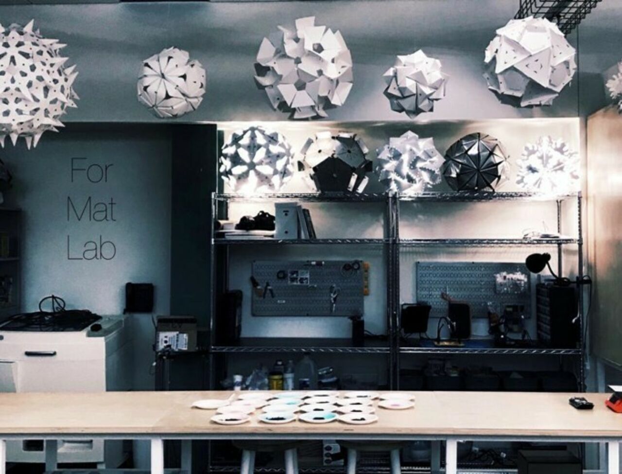 ForMatLab image showing several parametric paper lantern designs and other computational fabrications in a lab workspace