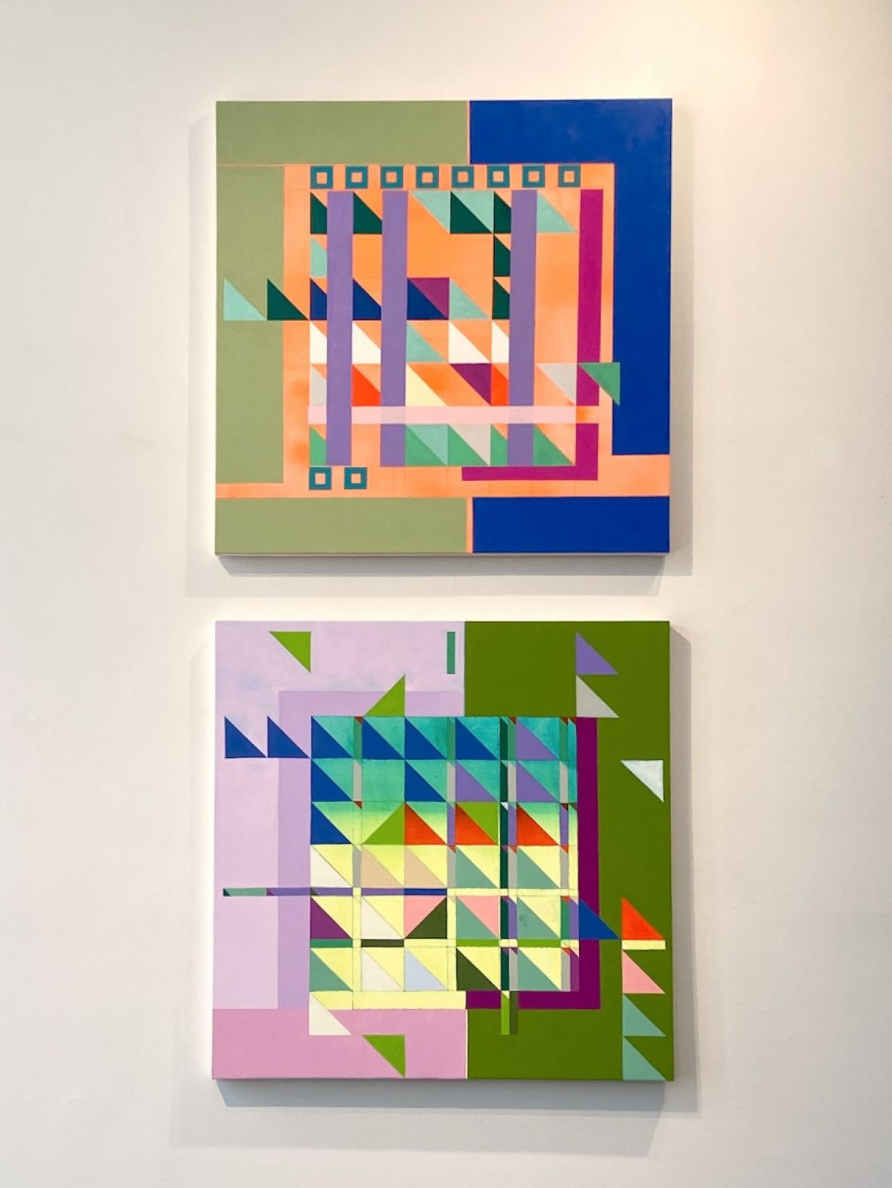Two geometric oil paintings on display.