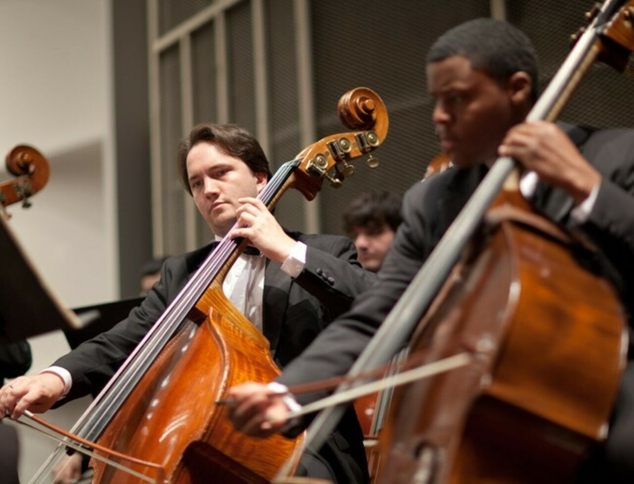 Two cellists playing with the Penn State Philharmonic Orchestra