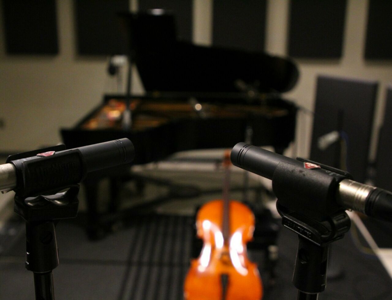 Microphones in the foreground, with instruments and recording equipment in the Penn State ROARS studio.