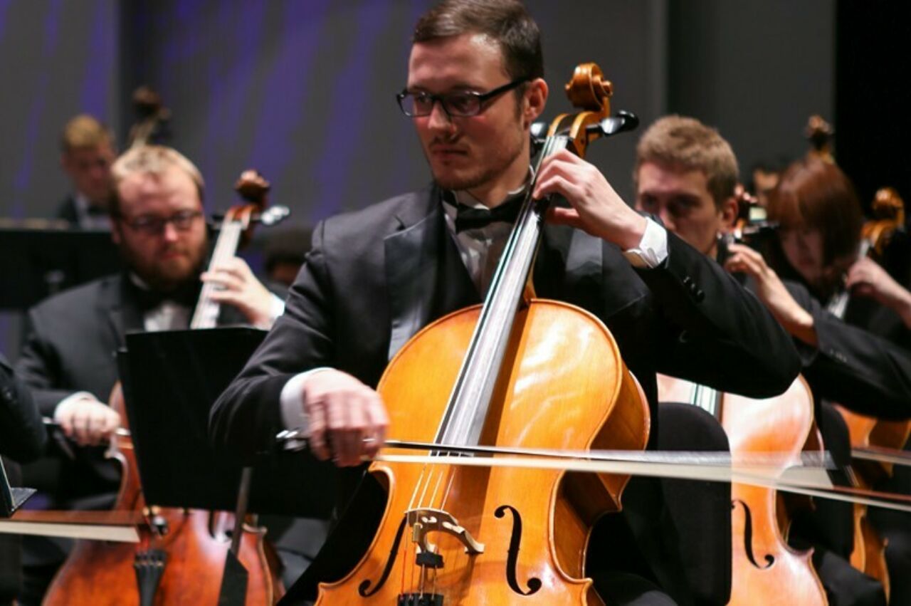 School of Music students dressed in tuxedos, playing their cellos during a Mosaic performance.