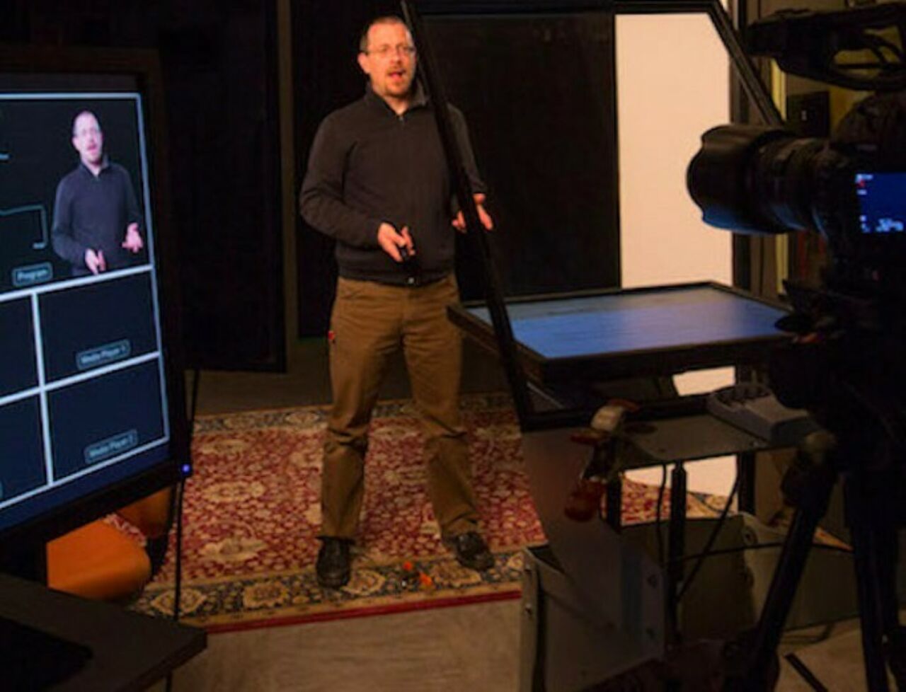 Architecture and landscape architecture professor Peter Aeschbacher filming online course content in a studio with camera and video monitors.