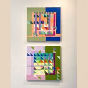 Two geometric oil paintings on display.