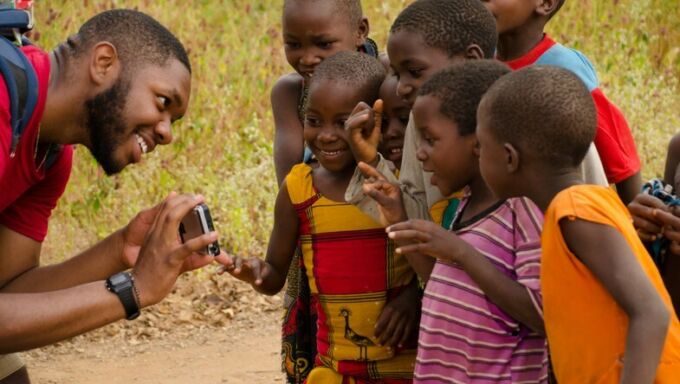 Student laughing with children in Tanzania