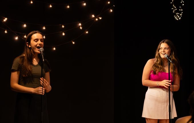 Two theatre camp females singing a duet together on stage.