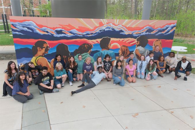 The Mending Walls Penn State committee and student painters pose for a group photo in front of the completed 2025 mural.