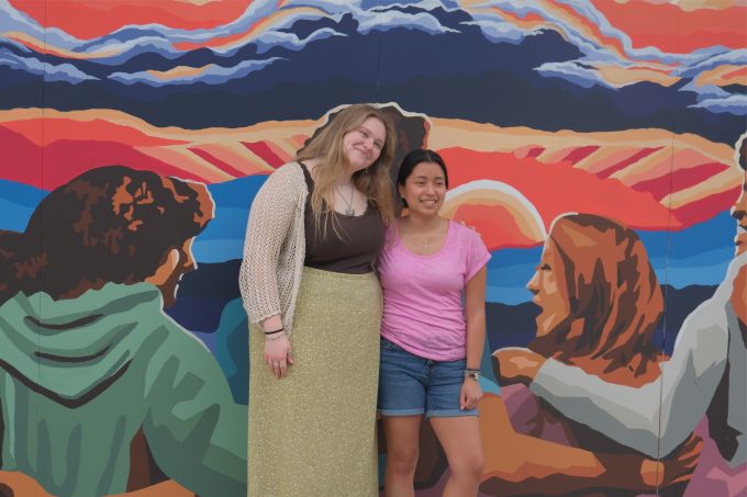 Mural designers, Sarah Nelson and Adriana Forsythe, stand in front of completed mural