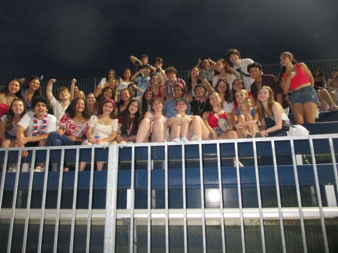 Students participating in the STATE Musical Theatre training program take a photo while at an outdoor Penn State University evening event.