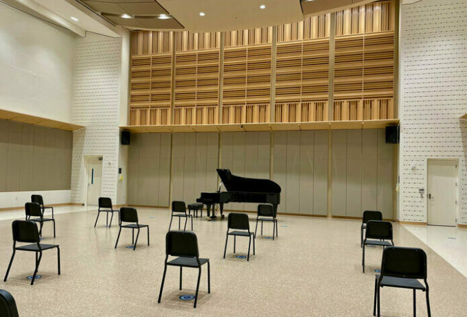 empty room with a few black chairs and a piano