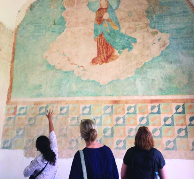 400-year-old Maya Christian artist's colorful mural painted in blues, greens, and coral shades, inside a church located on the Yucatán peninsula