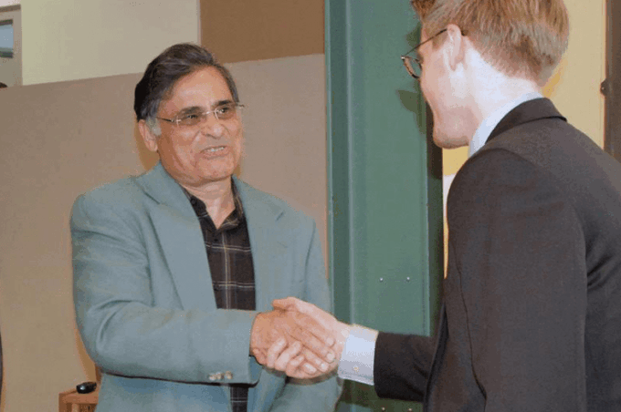Jawaid Haider shaking the hand of a student.
