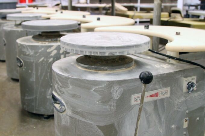A row of empty electric pottery wheels in the SoVA Ceramics Studio.