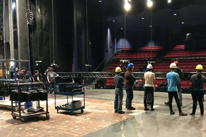 Playhouse Theatre stage crew assembling and reconfiguring lights on stage.