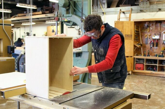 SoVa student using a table circulating saw to even out the edge of a wooden box.