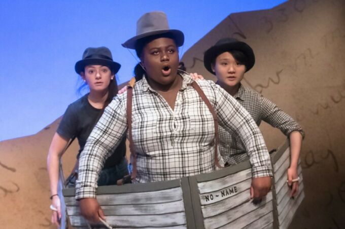 Three student performers in boats sing a song during the theatre production of Men on Boats.