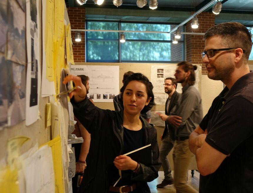 Landscape architecture SIP program student pointing to her designs and speaking with an instructor.