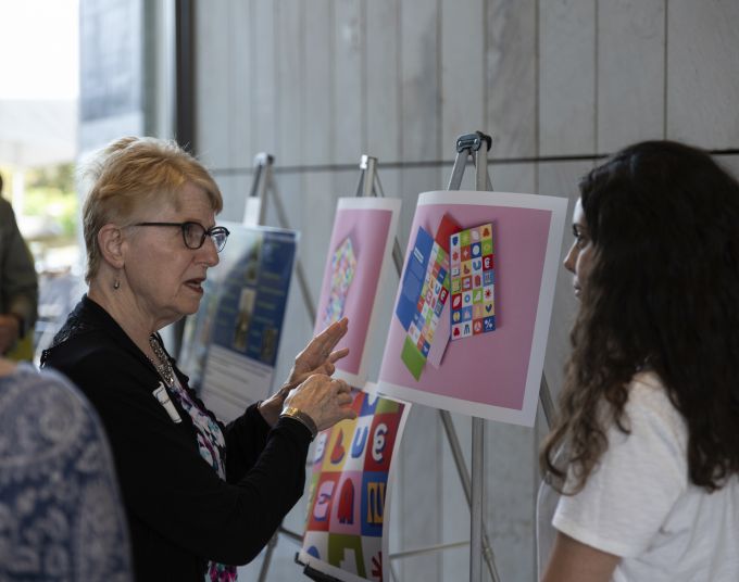 A donor attendee chatting with an A&A student about her work.