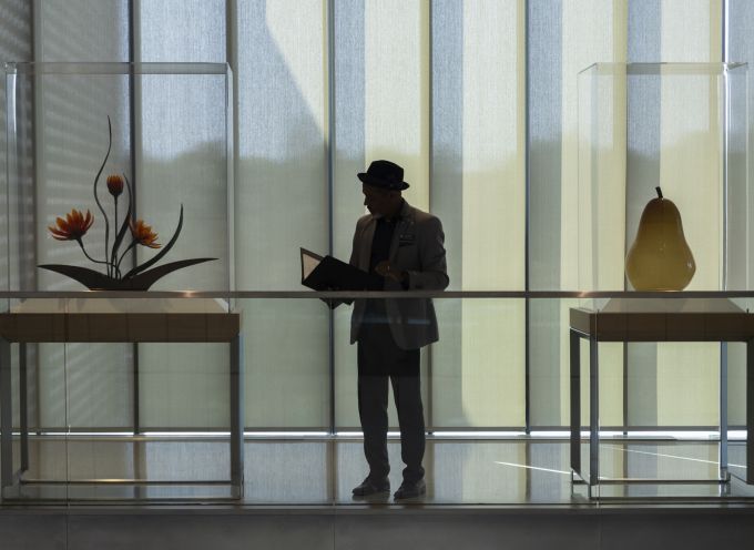 Dean Carpenter standing in between two sculptures on display.