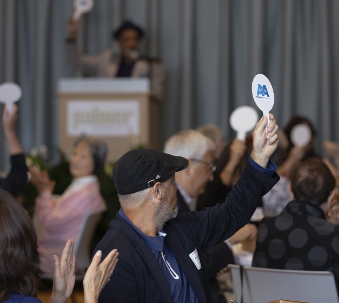 Attendees holding up A&A-branded paddles.