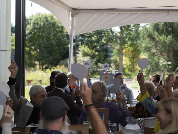 Attendees holding up A&A-branded paddles.