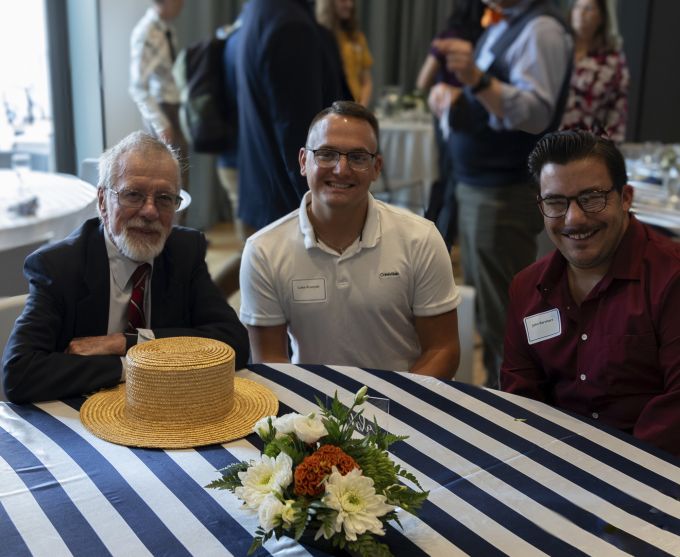 Three men smiling at the camera.