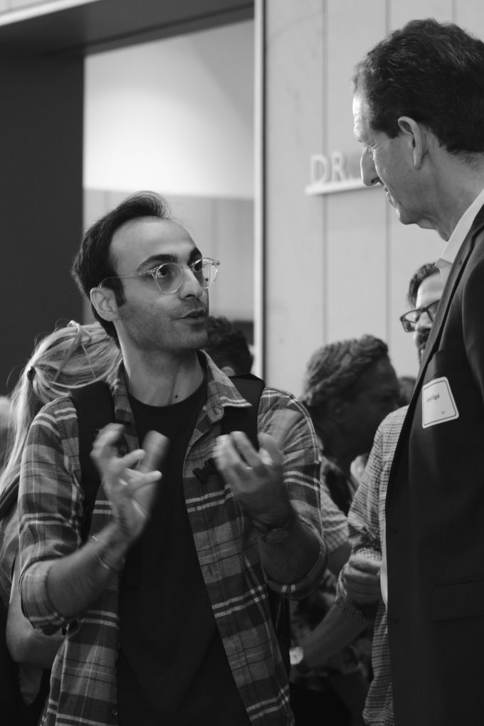 A man (left) speaking with Lloyd Sigal (right).