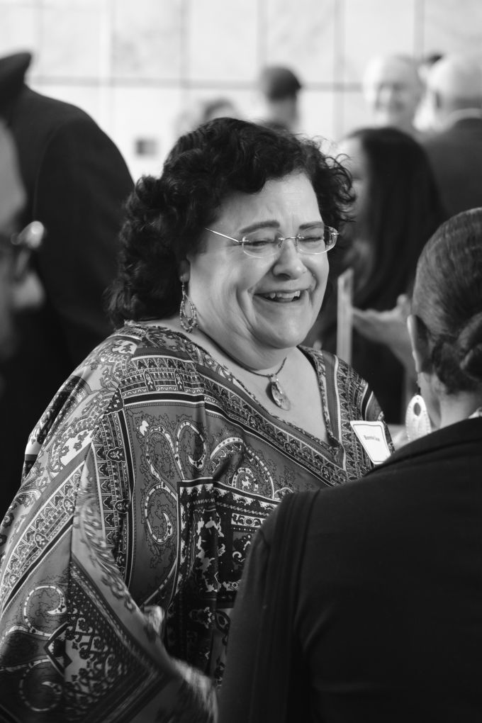 A woman smiling at another attendee.