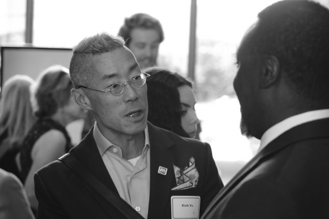 Kính Vu (left) speaking to another man.