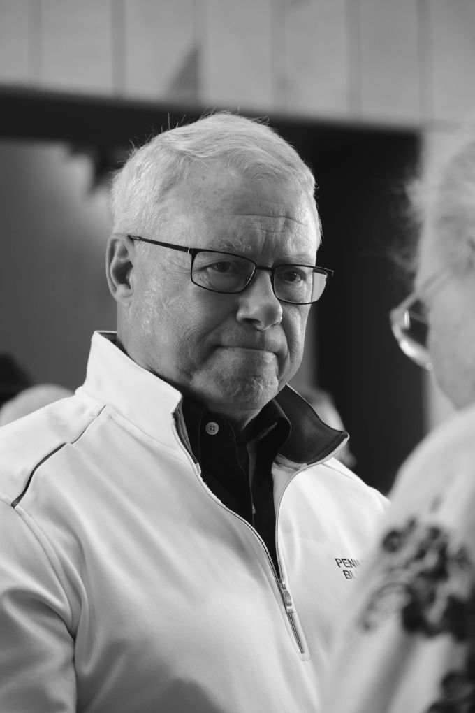 An elderly man speaking to a woman.