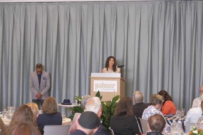 Attendees listening to the speaker, with Dean Carpenter standing to the left.