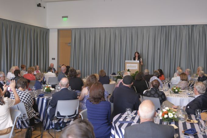 Donor Appreciation attendees sitting at tables, listening to the speaker at the podium.