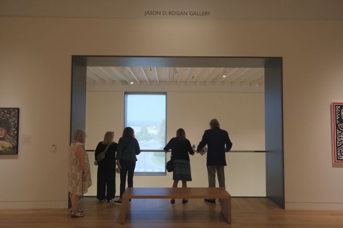 A group of people looking over the ledge on the upper level of the new Palmer Museum of Art.