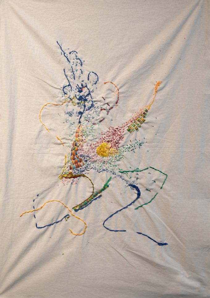 A piece of white fabric with colorful embroidery on it.