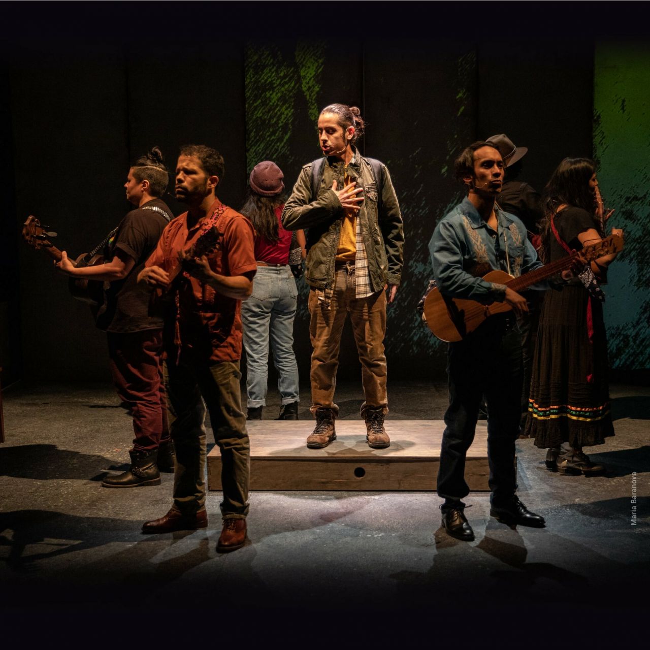 A group of men and women stand with their backs to a man in the center of their circle.