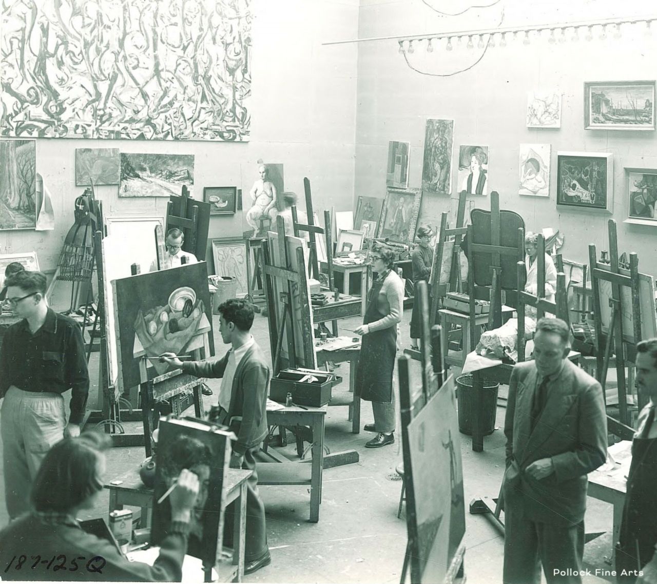 Students painting in large room with paintings on the wall, circa 1950s