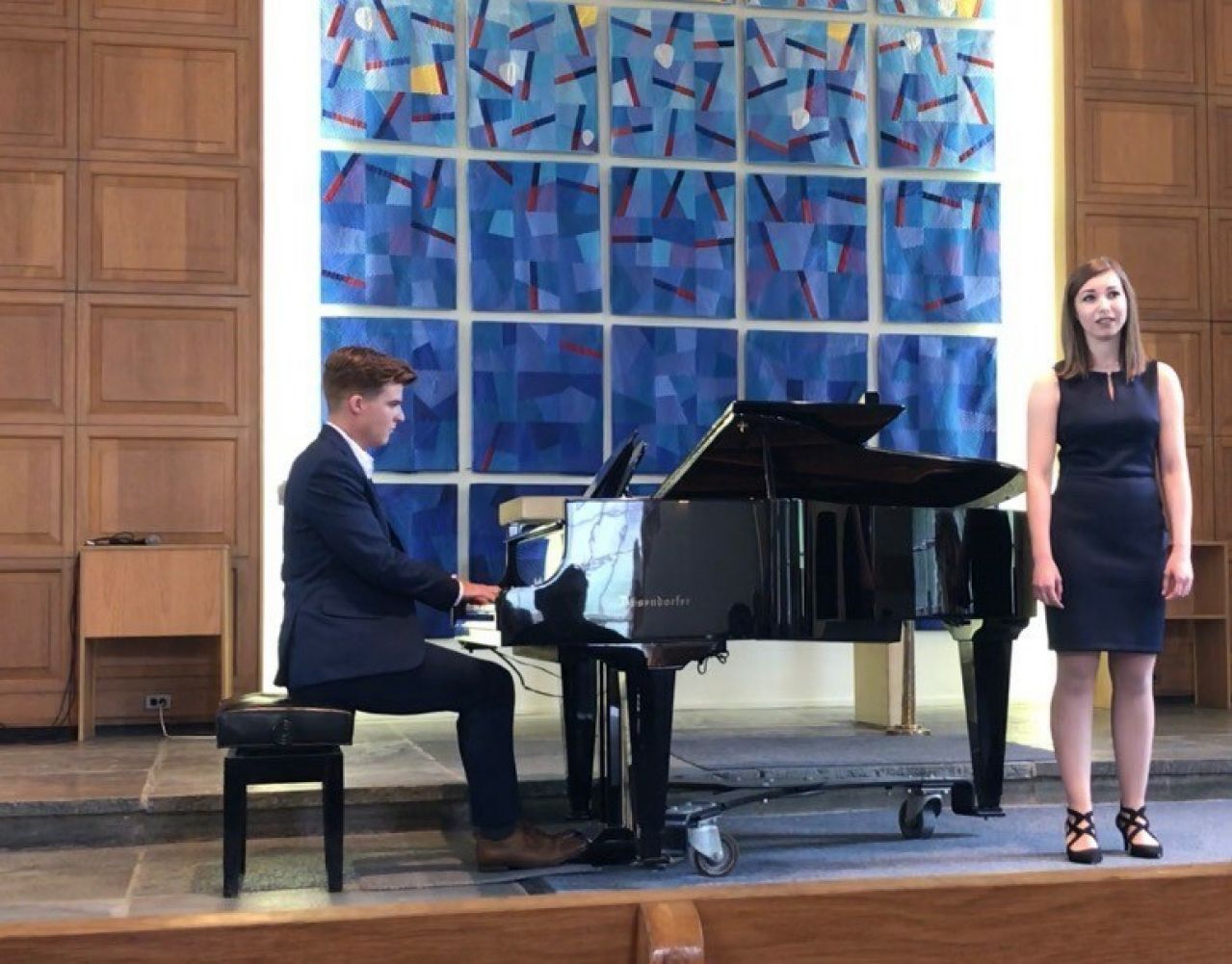 Meghan Nardella singing beside a piano
